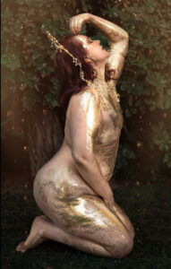 Nikki Lundberg posing with her body covered in gold paint